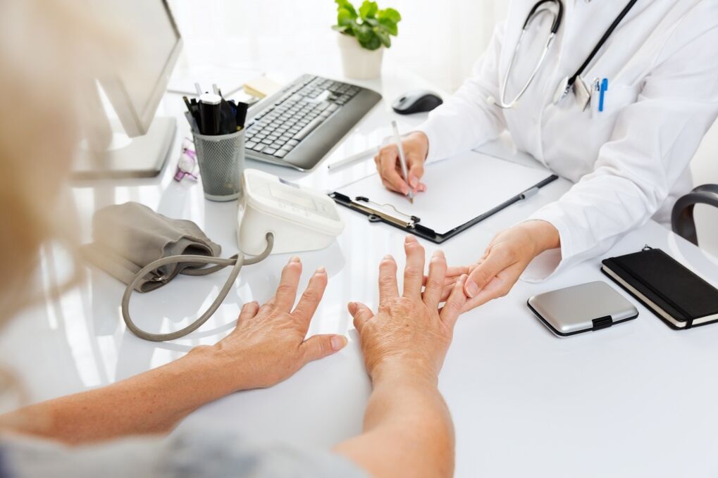 médico examina mãos com artrose